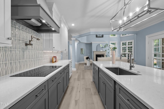 71012 Russell, Chapel Hill, NC 27517 - kitchen with a sink, wall chimney exhaust hood, black electric stovetop, white cabinetry, and decorative backsplash