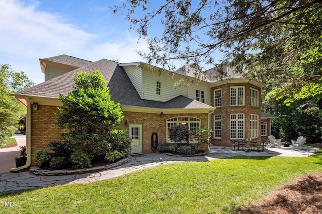 71012 Russell, Chapel Hill, NC 27517 - rear view of property featuring a patio, brick siding, a lawn, and roof with shingles