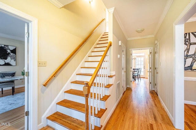 stairway featuring ornamental molding and hardwood / wood-style floors