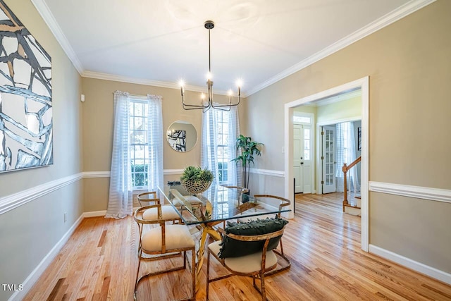 dining room with a chandelier, light hardwood / wood-style floors, and crown molding