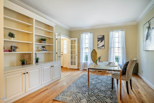 office area featuring light wood-type flooring, built in features, french doors, and crown molding