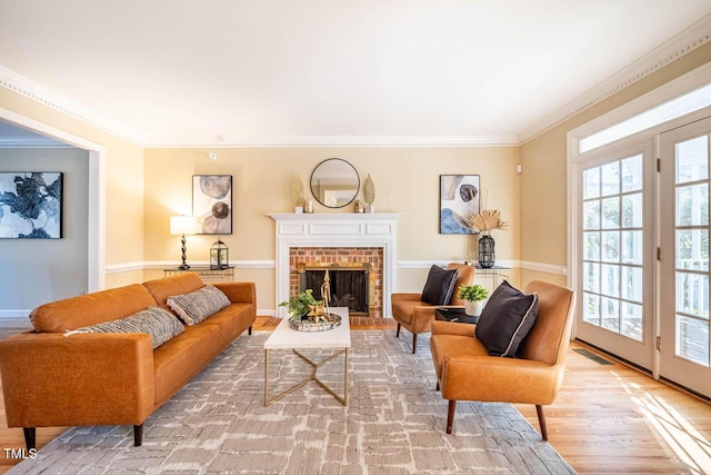 living room with a fireplace, ornamental molding, and light hardwood / wood-style floors