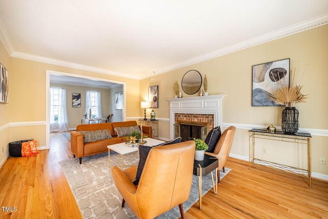 living room with a fireplace, light wood-type flooring, and crown molding