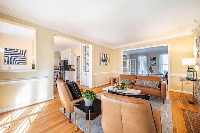 living room with light wood-type flooring and crown molding