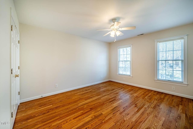 empty room with ceiling fan and light hardwood / wood-style floors