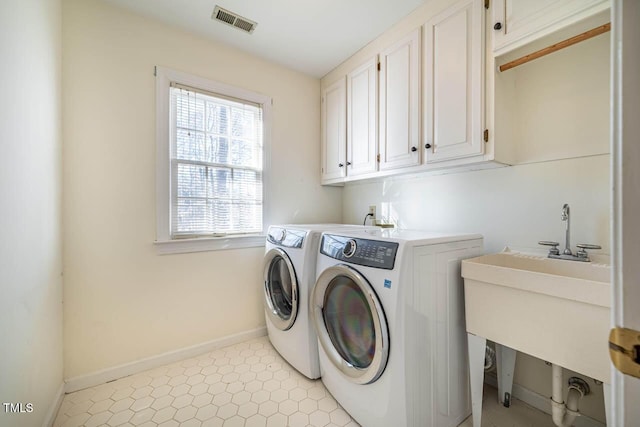 washroom with washing machine and dryer and cabinets