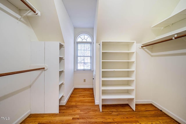 walk in closet with light hardwood / wood-style floors