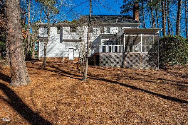 back of property featuring a deck and a sunroom