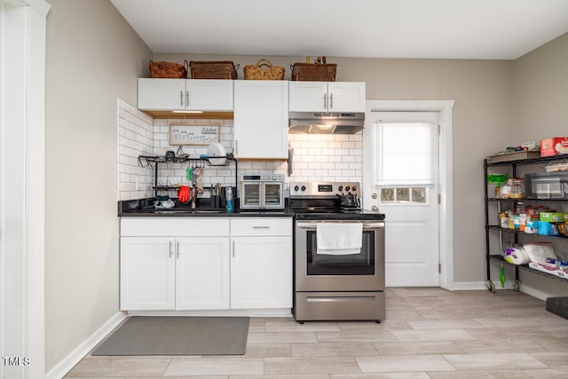 kitchen featuring stainless steel electric stove, backsplash, light hardwood / wood-style flooring, and white cabinets