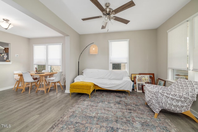 living room with ceiling fan and dark wood-type flooring