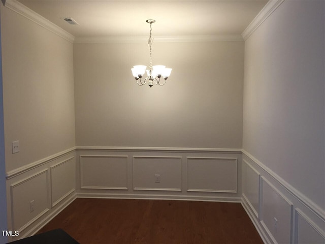 unfurnished dining area with an inviting chandelier, ornamental molding, and dark hardwood / wood-style floors