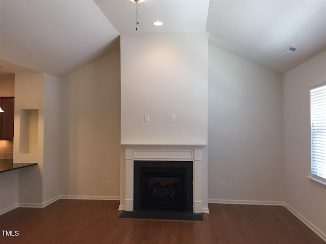 unfurnished living room featuring dark wood-type flooring, plenty of natural light, and vaulted ceiling