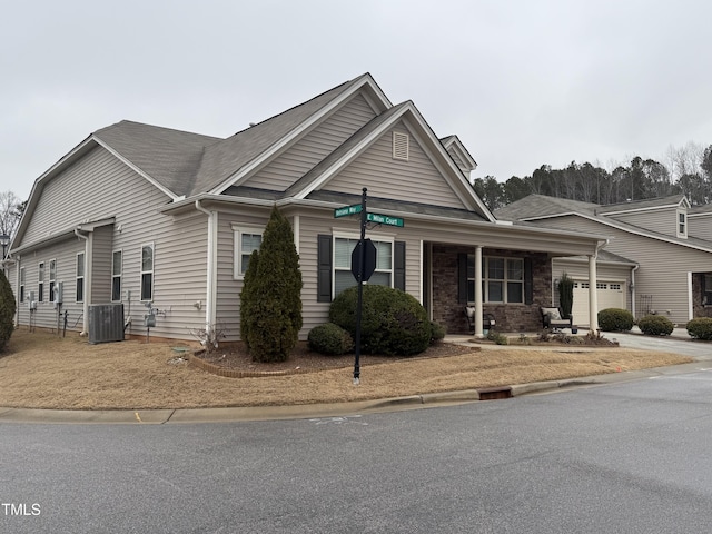 view of front of house with a garage and central air condition unit