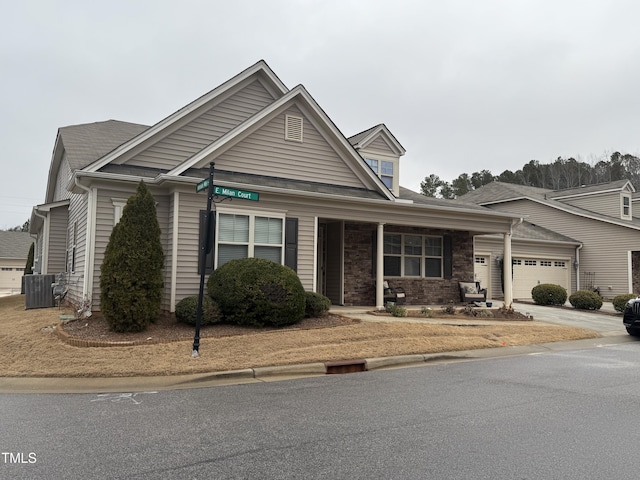 view of front facade featuring a garage, central AC, and covered porch