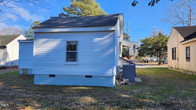 view of side of home with a lawn and central AC