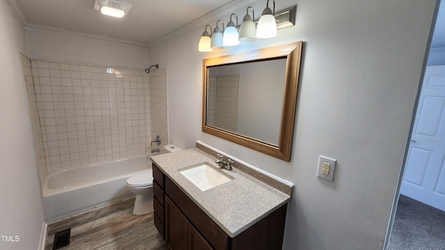 full bathroom featuring tiled shower / bath combo, crown molding, wood-type flooring, toilet, and vanity