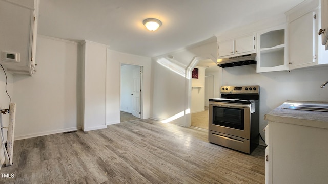 kitchen with white cabinets, light wood-type flooring, stainless steel electric stove, and sink