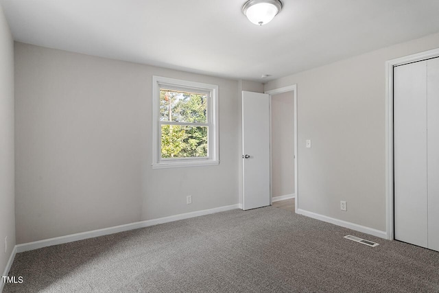 unfurnished bedroom with a closet and carpet flooring