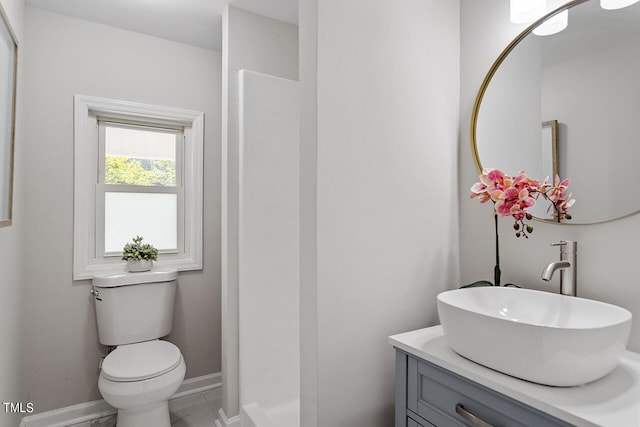 bathroom featuring toilet, walk in shower, and vanity