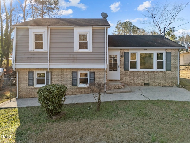 tri-level home featuring a front yard and a patio