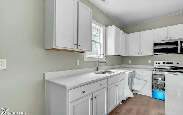 kitchen featuring stainless steel appliances, white cabinets, sink, and hardwood / wood-style floors