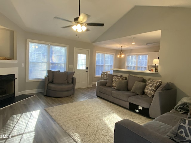 living room with lofted ceiling, ceiling fan with notable chandelier, and hardwood / wood-style floors