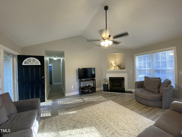 living room featuring lofted ceiling, ceiling fan, and light hardwood / wood-style flooring