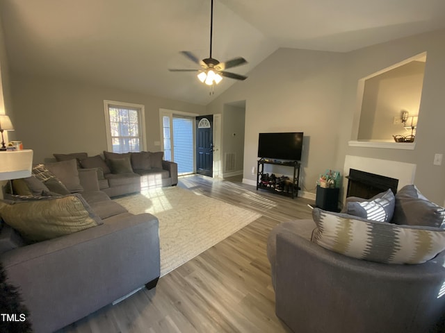 living room with wood-type flooring, ceiling fan, and vaulted ceiling