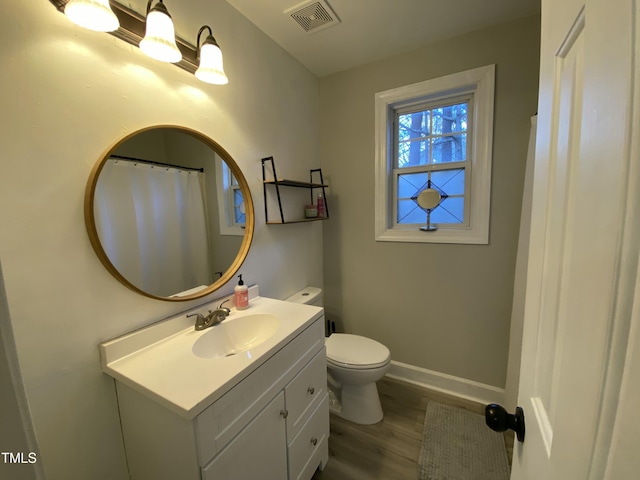 bathroom with toilet, hardwood / wood-style flooring, and vanity