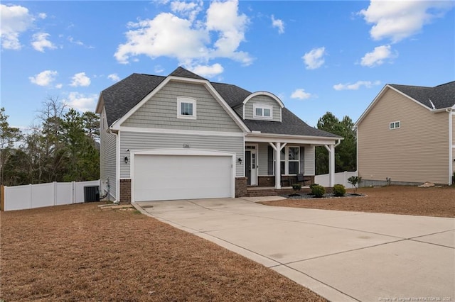 craftsman inspired home featuring a porch, a garage, and cooling unit