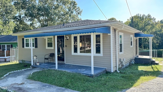 bungalow-style house with a front lawn and a patio