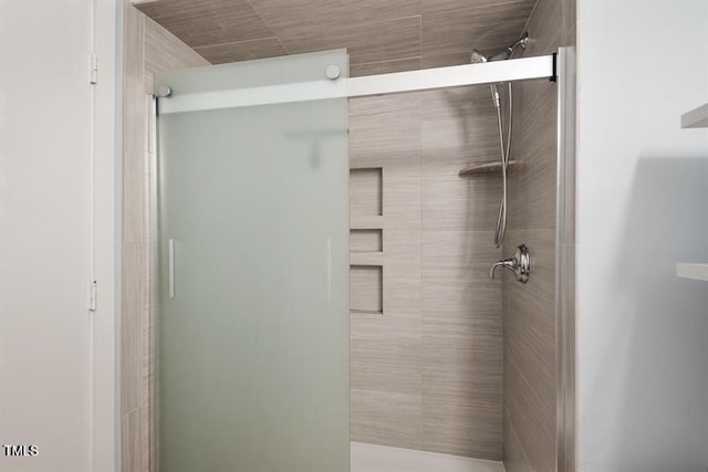 bathroom featuring a shower with shower door