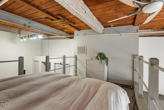 bedroom featuring beam ceiling, wood ceiling, and rail lighting