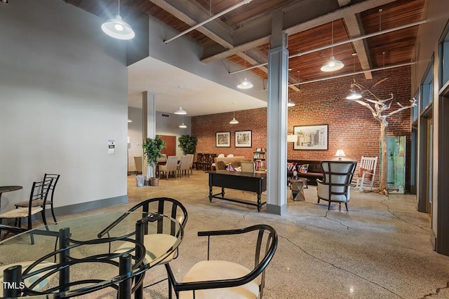 interior space featuring a high ceiling and brick wall