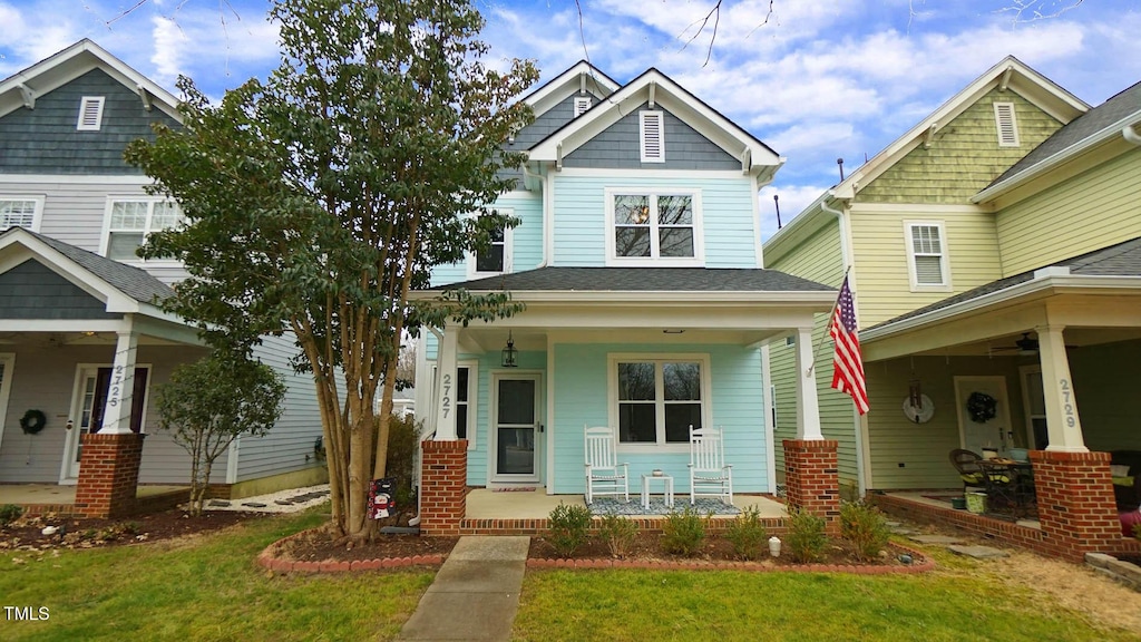 craftsman-style home featuring covered porch and a front lawn