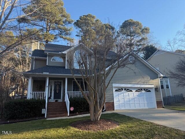 view of front facade with a front yard, covered porch, and a garage