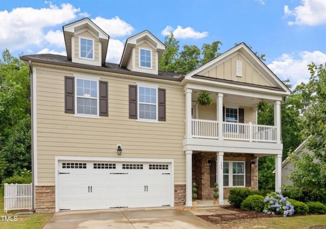 143 Thornbury St, Clayton, NC 27527 - view of front facade with a balcony, an attached garage, driveway, board and batten siding, and covered porch