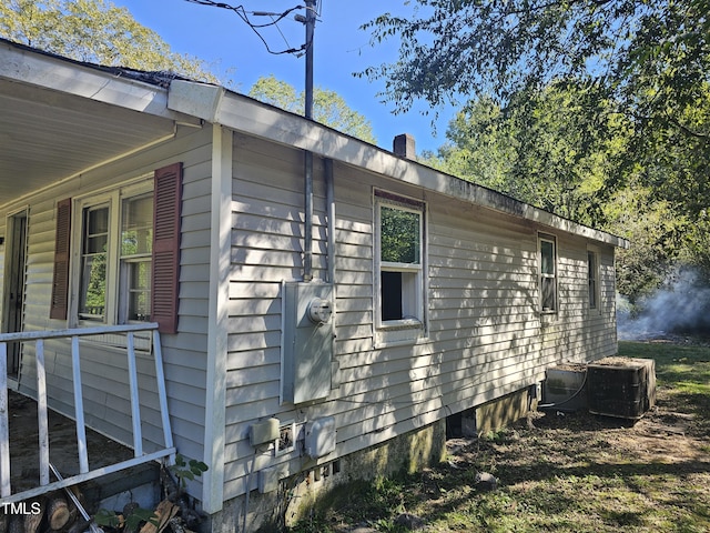 view of side of home with central AC