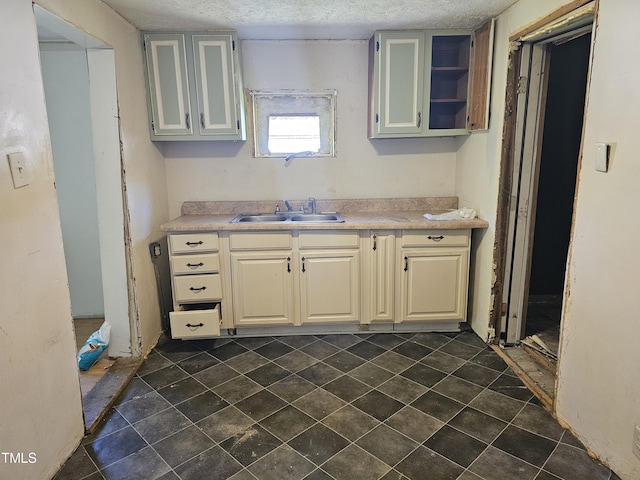 kitchen featuring a textured ceiling and sink