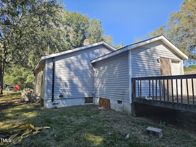 view of side of home with a yard and a wooden deck