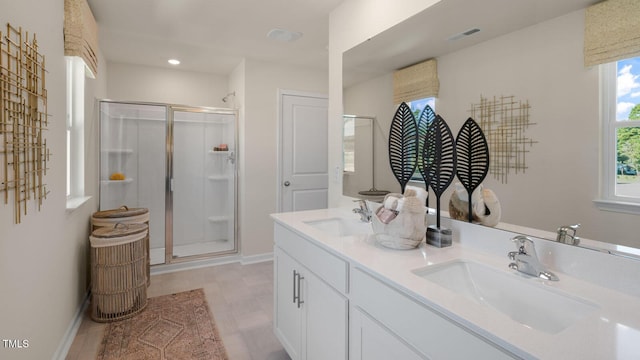 bathroom with a shower with shower door and vanity