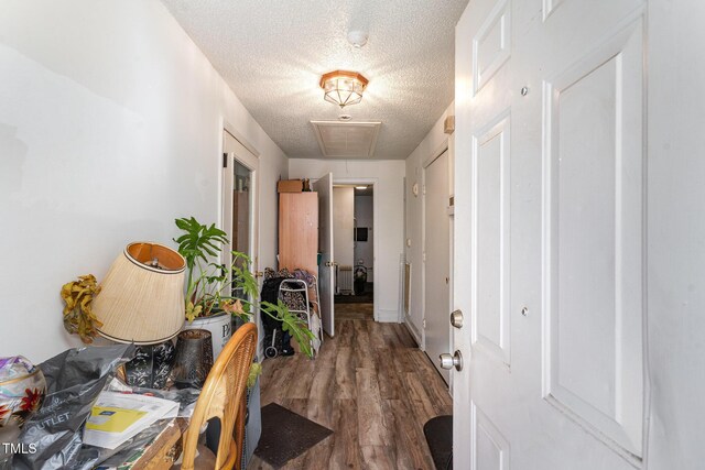 hallway featuring dark hardwood / wood-style floors and a textured ceiling