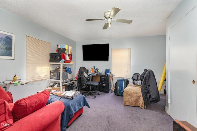 bedroom featuring a textured ceiling, ceiling fan, and carpet