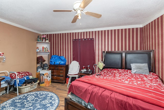 bedroom featuring crown molding, hardwood / wood-style floors, a textured ceiling, and ceiling fan