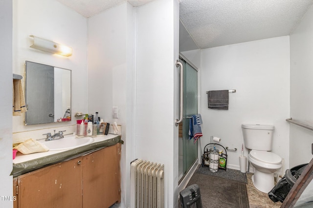 bathroom featuring vanity, radiator heating unit, a textured ceiling, and a shower with shower door