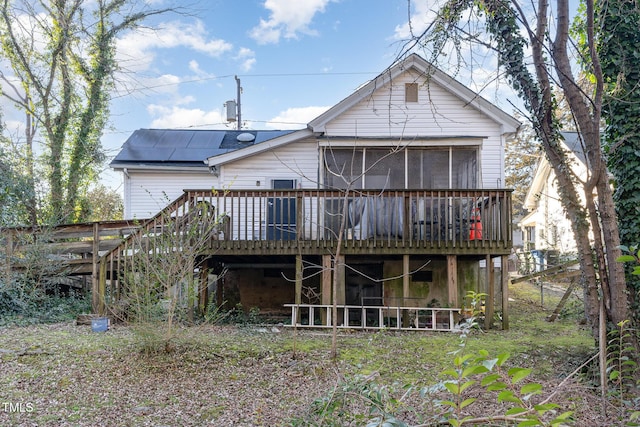 back of house featuring a wooden deck and a sunroom