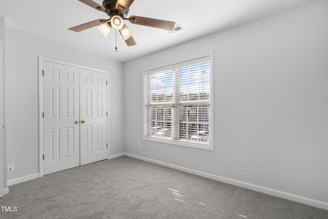 unfurnished bedroom with carpet, a closet, and ceiling fan