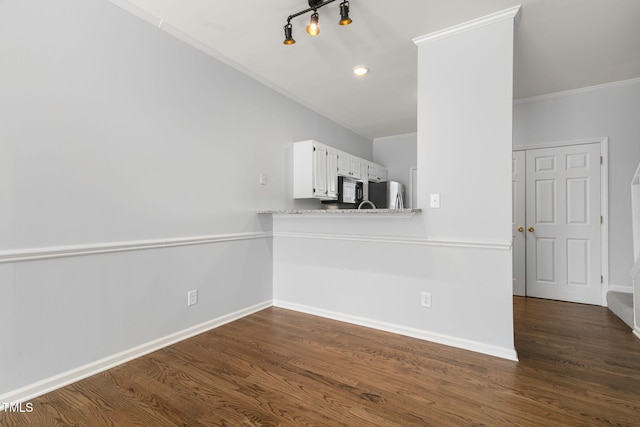 unfurnished living room with ornamental molding and dark hardwood / wood-style floors