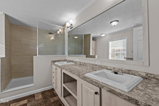 bathroom featuring vanity, a textured ceiling, and a tile shower