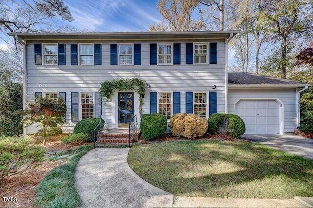 colonial home with a front yard and a garage